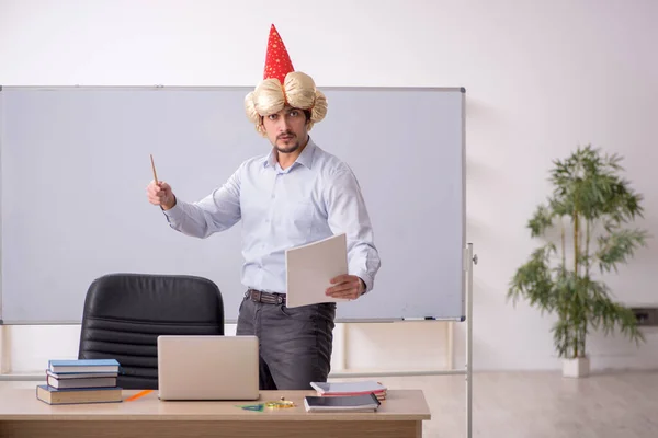 Funny young male teacher magician in the classroom