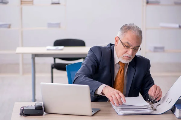 Ältere männliche Angestellte bei der Arbeit im Büro — Stockfoto