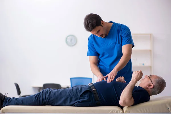 Viejo visitando joven doctor masculino — Foto de Stock