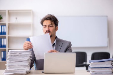 Genç işadamı ve ofiste çok fazla iş var.