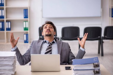 Genç işadamı ve ofiste çok fazla iş var.