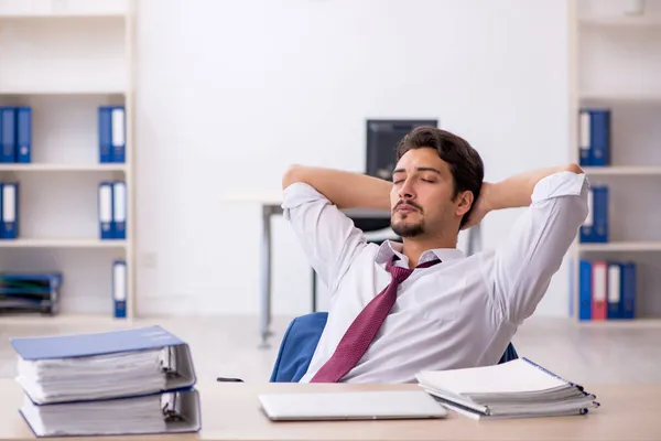 Giovane dipendente maschio infelice con un lavoro eccessivo in ufficio — Foto Stock