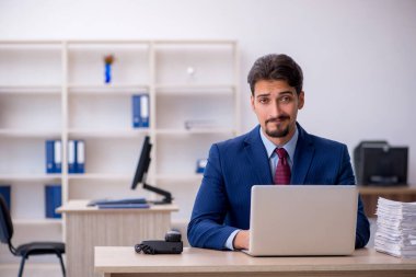 Genç işadamı ve ofiste çok fazla iş var.