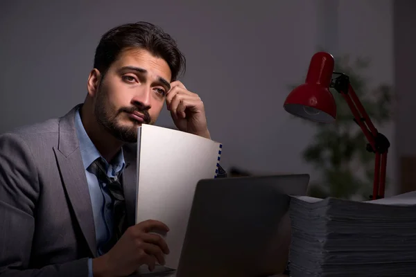 Ung manlig anställd som arbetar sent på kontoret — Stockfoto