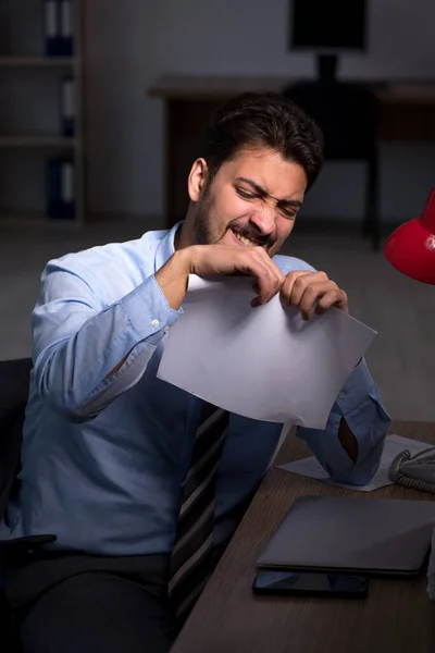 Jeune employé masculin travaillant tard au bureau — Photo