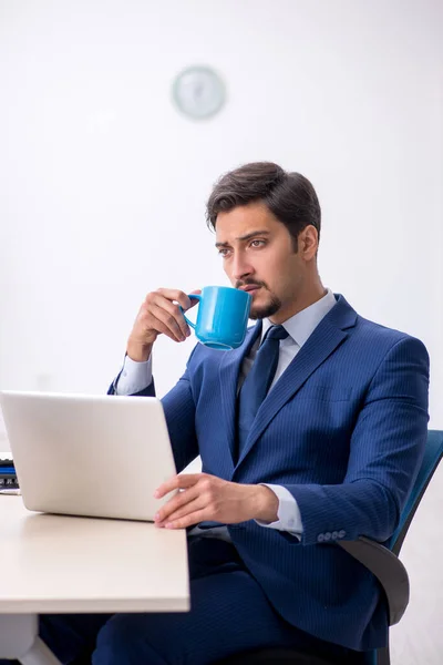 Jonge mannelijke werknemer die koffie drinkt tijdens de pauze — Stockfoto