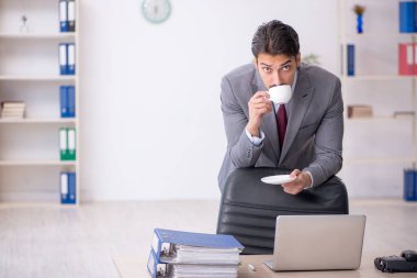 Molada kahve içen genç bir erkek.