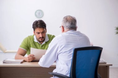 Genç adam ziyaret eski erkek doktor