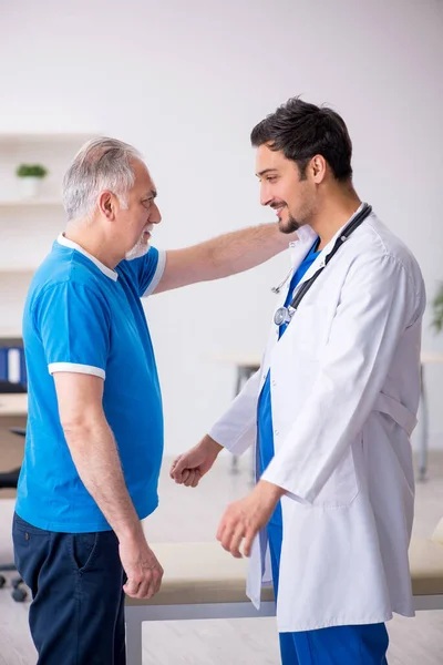 Alt männlich patient besuch jung männlich doktor — Stockfoto