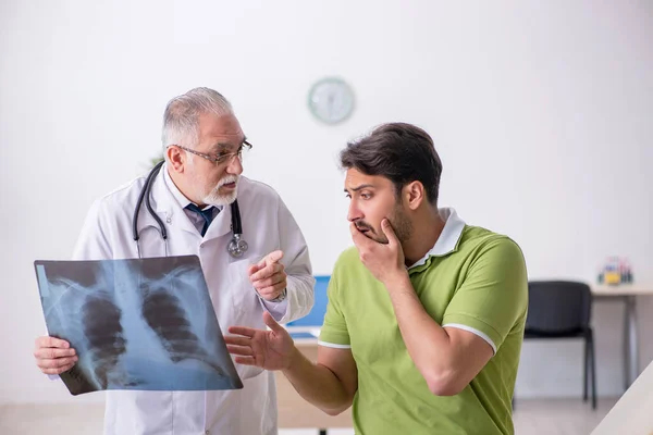 Молодой человек посещает старого врача-рентгенолога — стоковое фото