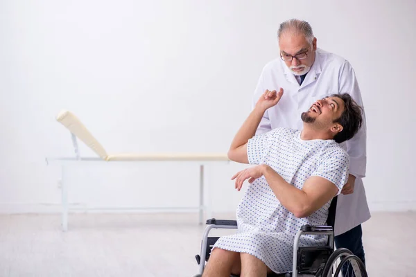 Old male doctor psychiatrist examining young disabled patient