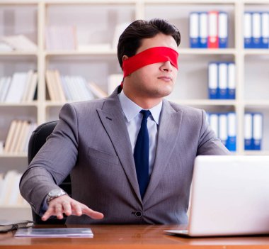 Ofiste masasında oturan gözü bağlı iş adamı.