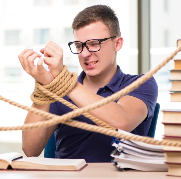 Jovem estudante forçado a estudar amarrado — Fotografia de Stock