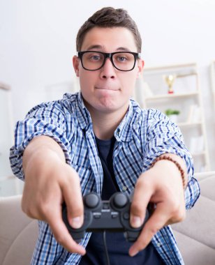 Genç adam evde bilgisayar oyunu oynuyor.