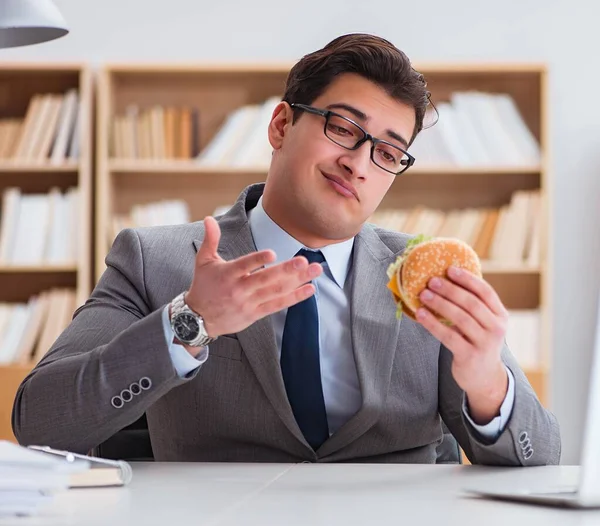 Hungry funny businessman eating junk food sandwich — Stock Photo, Image