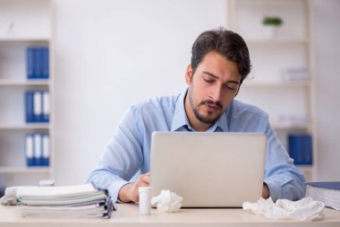 İş yerinde acı çeken genç bir erkek işçi.