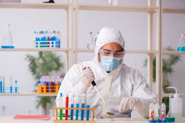 Salgın sırasında laboratuvarda çalışan genç bir kimyager.