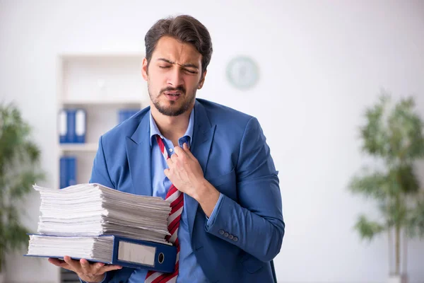 Ung manlig anställd missnöjd med överdrivet arbete på kontoret — Stockfoto