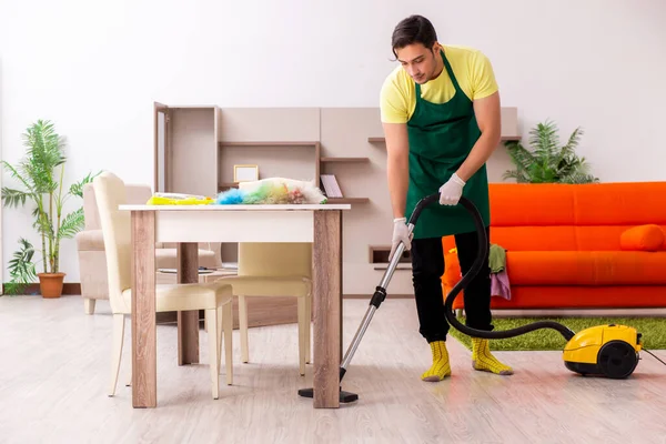 Joven contratista masculino limpiando la casa en interiores — Foto de Stock