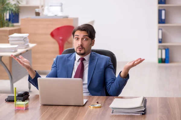 Junge männliche Mitarbeiter sitzen am Arbeitsplatz — Stockfoto