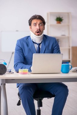 İş yerinde otururken geçirdiği kazadan sonra genç bir erkek.