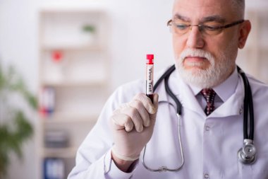 Klinikte çalışan yaşlı bir erkek hematolog.