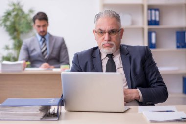 Ofiste çalışan iki erkek çalışan.