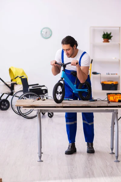 室内修理自行车的年轻男性修理工 — 图库照片