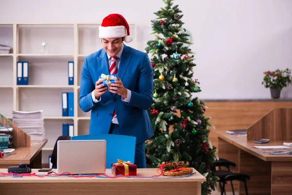 Mladý muž zaměstnanec slaví Vánoce na pracovišti — Stock fotografie