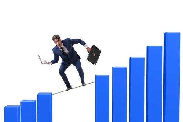 Businessman walking on tight rope between bar chart — Stock Photo, Image