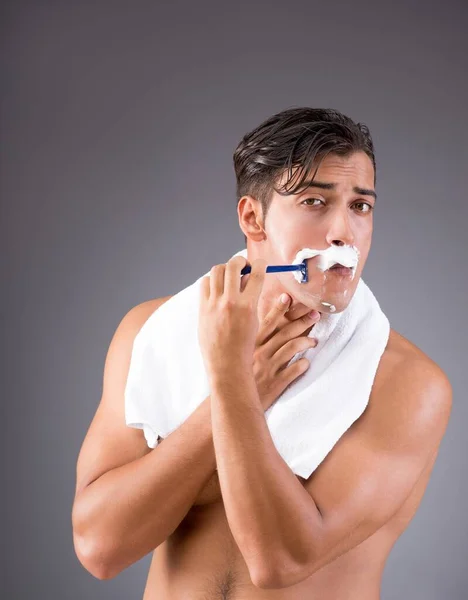 Handsome man shaving against dark background — Stock Photo, Image