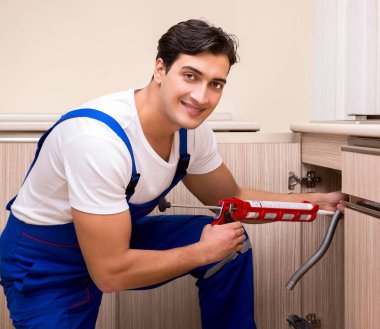 Mutfakta çalışan genç tamirci.