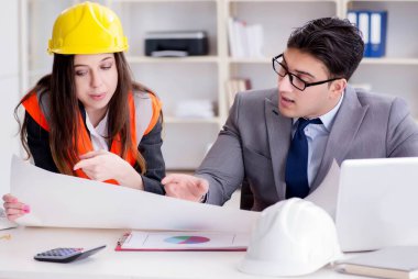 İnşaat ustabaşı çizimleri gözden geçiriyor