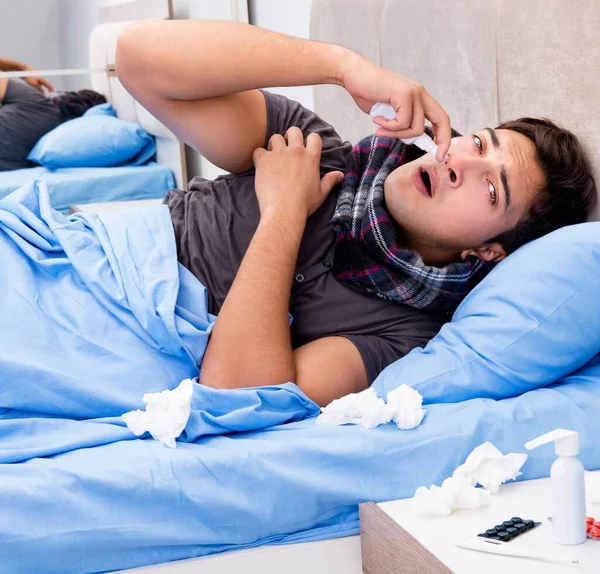 Nemocný muž v posteli brát léky a léky — Stock fotografie