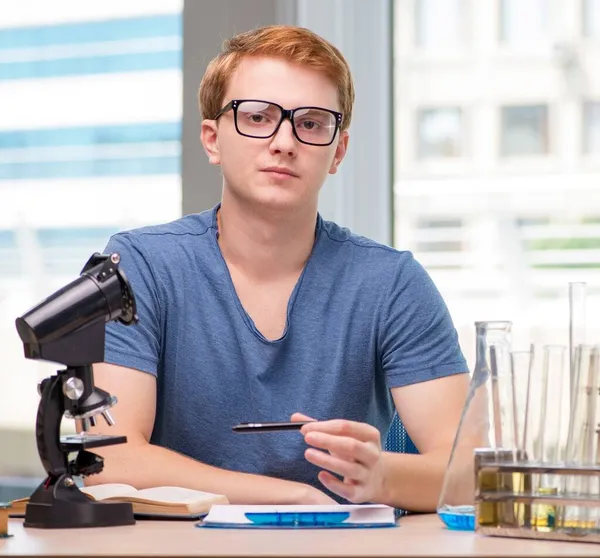 Jovem estudante cansado e exausto se preparando para o exame de química — Fotografia de Stock