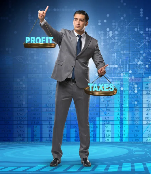 Homme d'affaires comparant bénéfices et impôts — Photo
