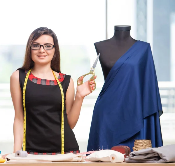 Mulher alfaiate trabalhando em roupas novas — Fotografia de Stock