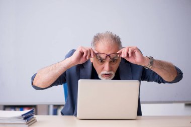 Tele-eğitim konseptinde yaşlı bir erkek öğretmen