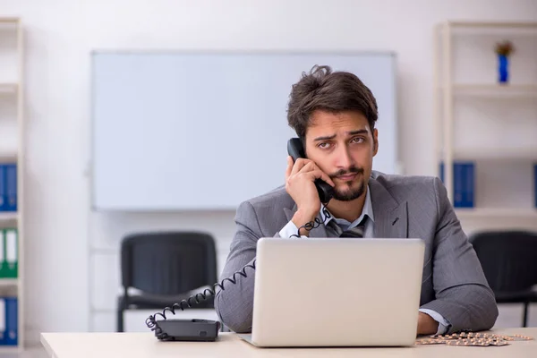 Jeune homme d'affaires travailleur souffrant sur le lieu de travail — Photo