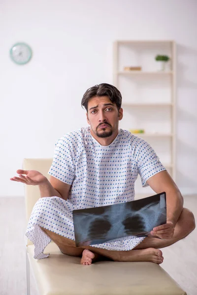 Jovem paciente do sexo masculino olhando raio-x na clínica — Fotografia de Stock