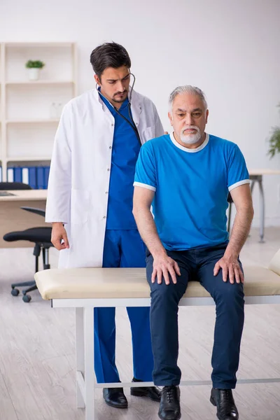 Yaşlı erkek hasta genç erkek doktoru ziyaret ediyor. — Stok fotoğraf