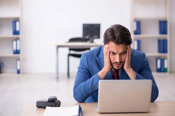 Joven empleado masculino descontento con el trabajo excesivo en la oficina — Foto de Stock