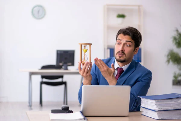 Joven empleado masculino en concepto de gestión del tiempo —  Fotos de Stock