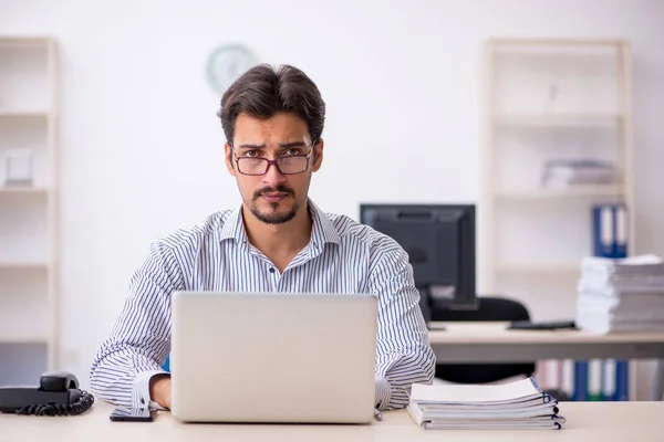 Giovane dipendente maschio e troppo lavoro in ufficio — Foto Stock