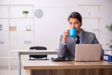 Molada kahve içen genç bir erkek.