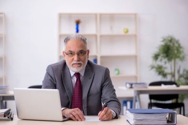 Ofiste çalışan yaşlı bir erkek.