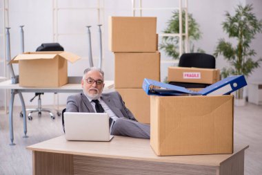 Old male employee in relocation concept clipart