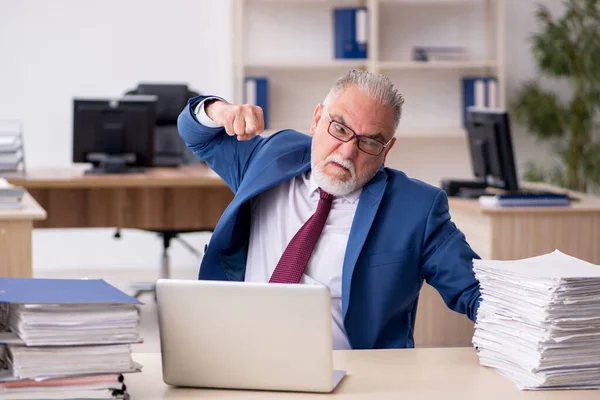 Vieil employé masculin mécontent du travail excessif au bureau — Photo