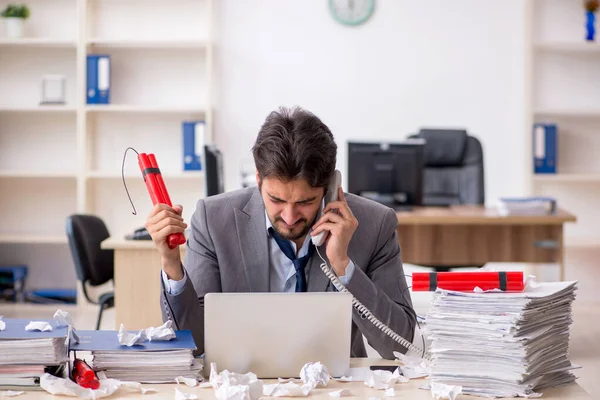 Joven empleado masculino y demasiado trabajo en la oficina — Foto de Stock