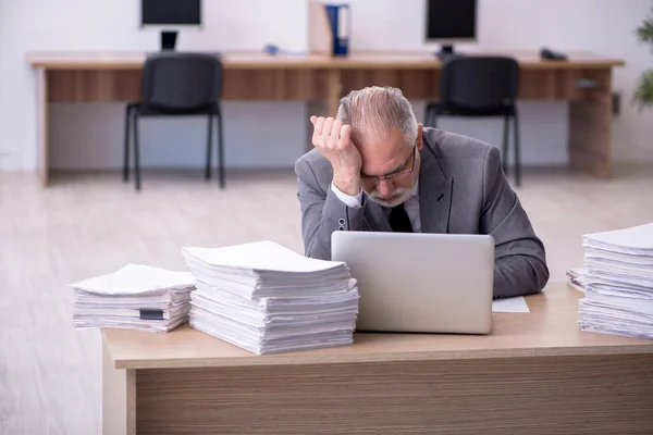 Gammal manlig anställd missnöjd med överdrivet arbete på kontoret — Stockfoto